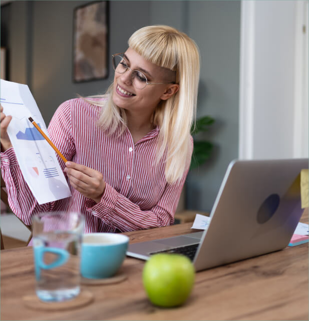 Smiling woman looking at a financial graph on paper